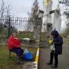 ​Російське вторгнення в Україну : Церква у Бучі. Бабуся продає букети з вербових гілок. 