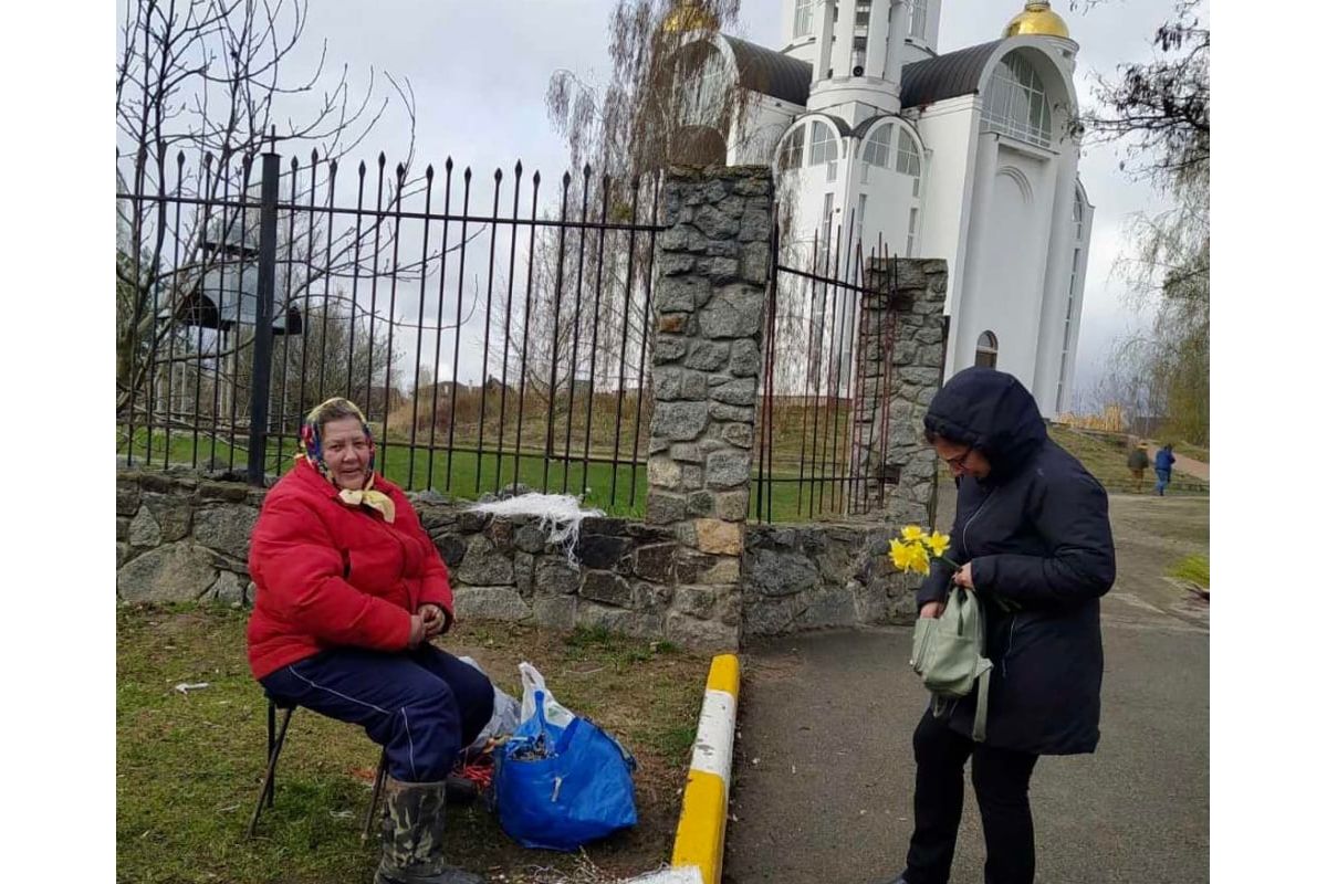 Російське вторгнення в Україну : Церква у Бучі. Бабуся продає букети з вербових гілок. 