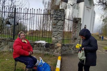 Російське вторгнення в Україну : Церква у Бучі. Бабуся продає букети з вербових гілок.  Російське вторгнення в Україну : Церква у Бучі. Бабуся продає букети з вербових гілок.