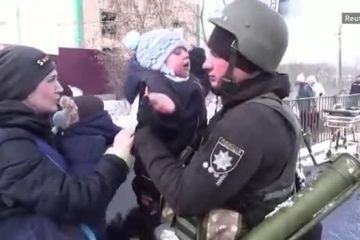 Український поліцейський в Ірпені прощається із сином, якого вивозять у безпечне місце Український поліцейський в Ірпені прощається із сином, якого вивозять у безпечне місце